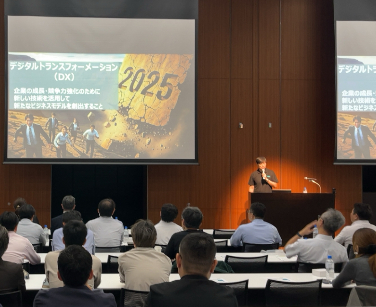 登壇者と会場・登壇スライドが同時に写る写真